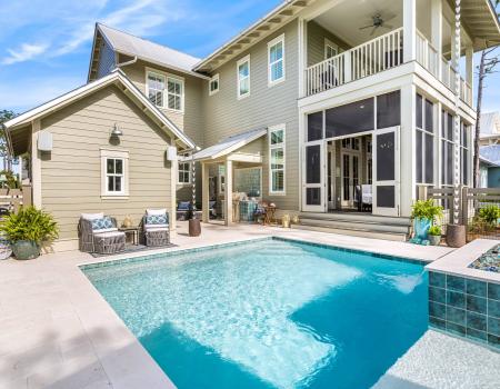 A view of the back of a property, featuring the private fenced-in pool.